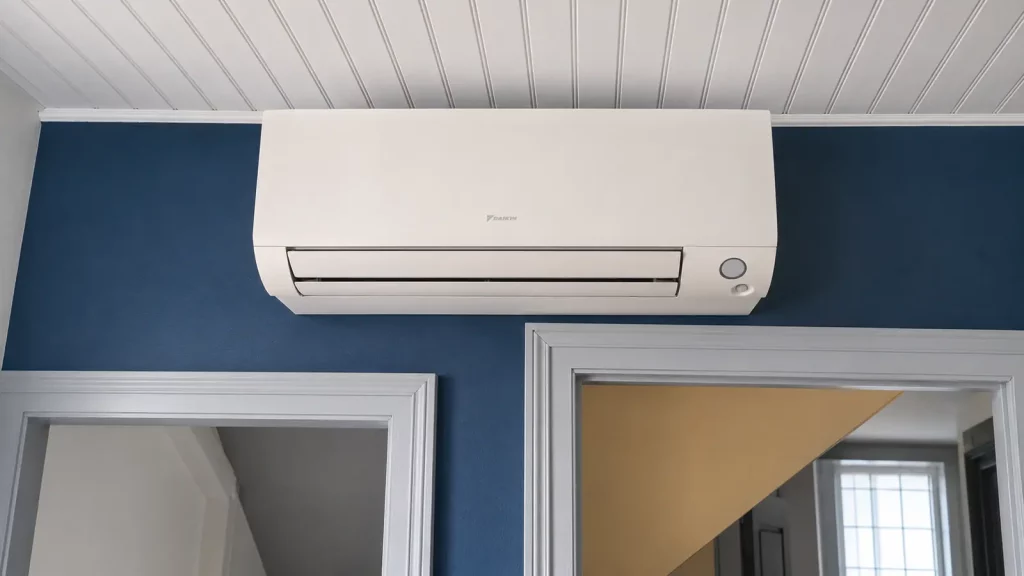 Climatisation murale Daikin installée sur un mur bleu